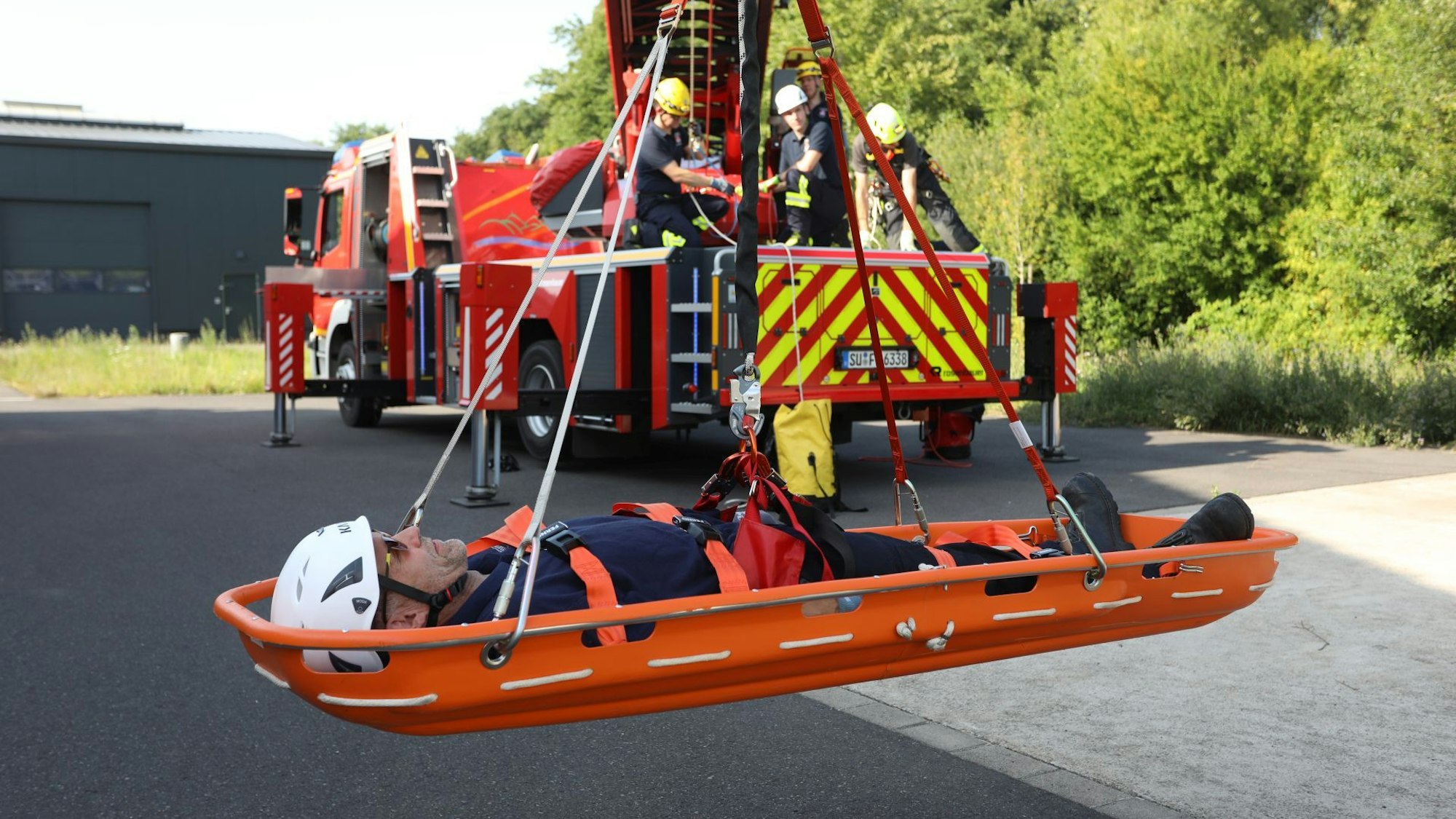 Mit Seilen und Flaschenzügen wurde die Schleifkorbtrage mit dem „Verletzten“ (Stefan Fetting) unter dem Korb der Drehleiter befestigt und sicher auf den Boden gebracht.