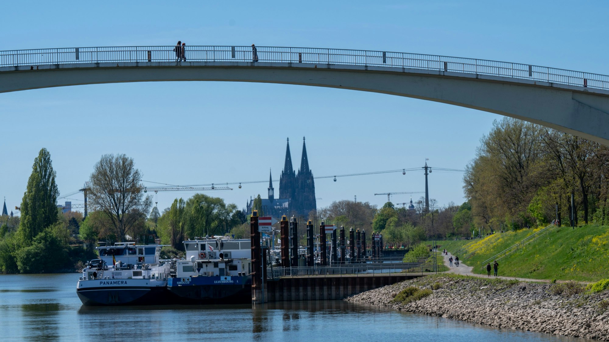 17.04.2022, Köln: Die Katzenbuckelbrücke überspannt die Einfahrt zum Mülheimer Hafen. Orte am Wasser sind bei vielen Besuchern beliebt. Foto: Uwe Weiser