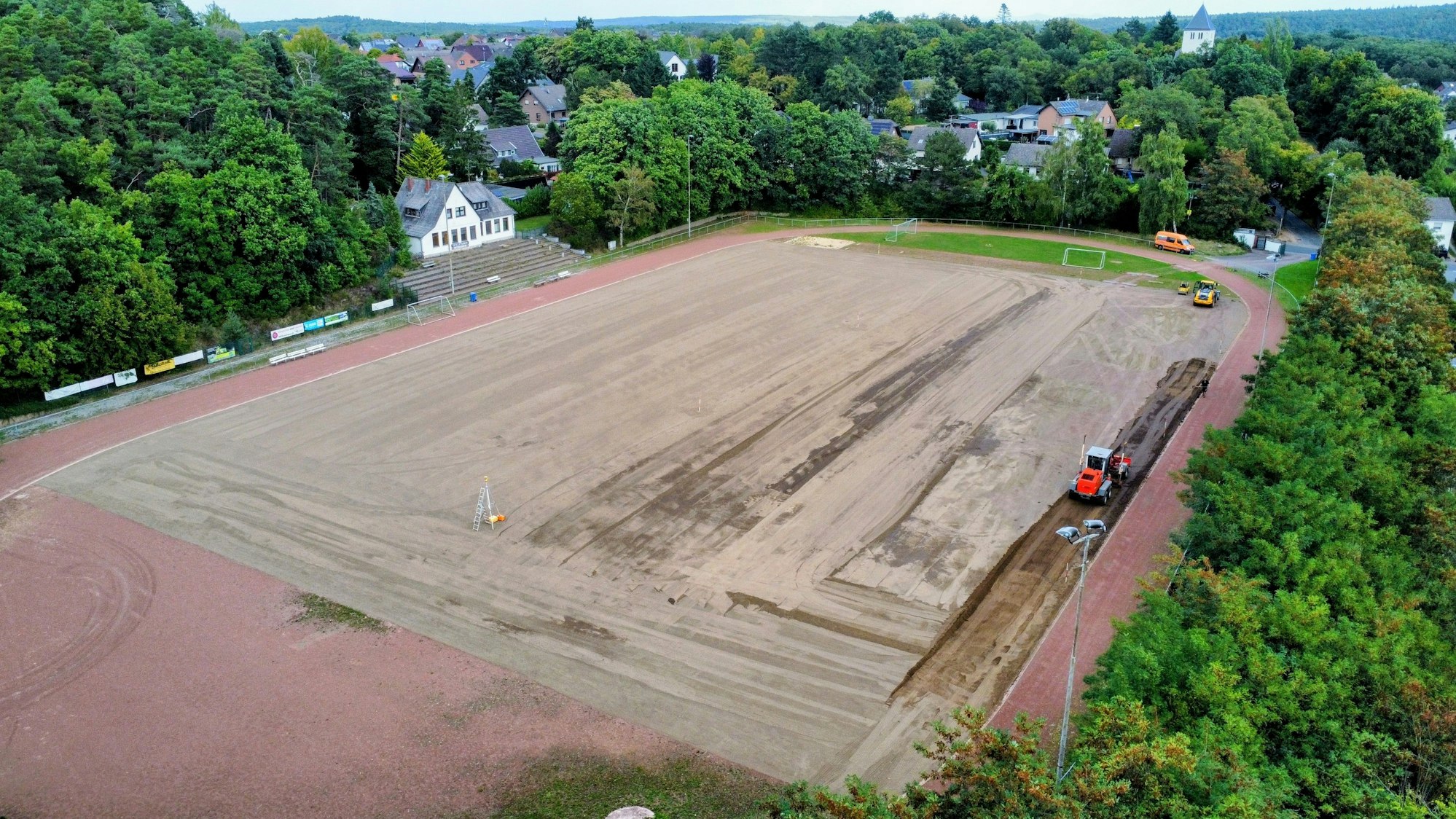 Die Luftaufnahme zeigt das Eifelstadion in Mechernich, wo derzeit Arbeiten zum Umbau des Tennenplatzes zu einem Rasenplatz stattfinden.