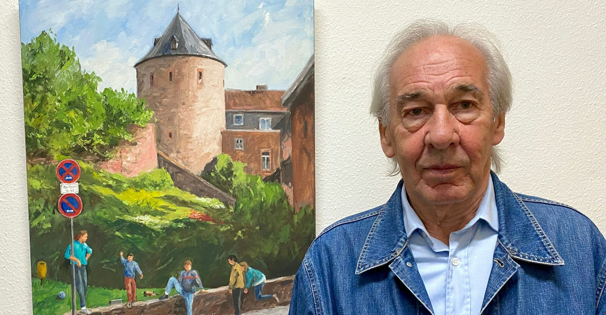 Der Künstler steht rechts neben einem seiner Ölgemälde mit einer Stadtansicht von Euskirchen.