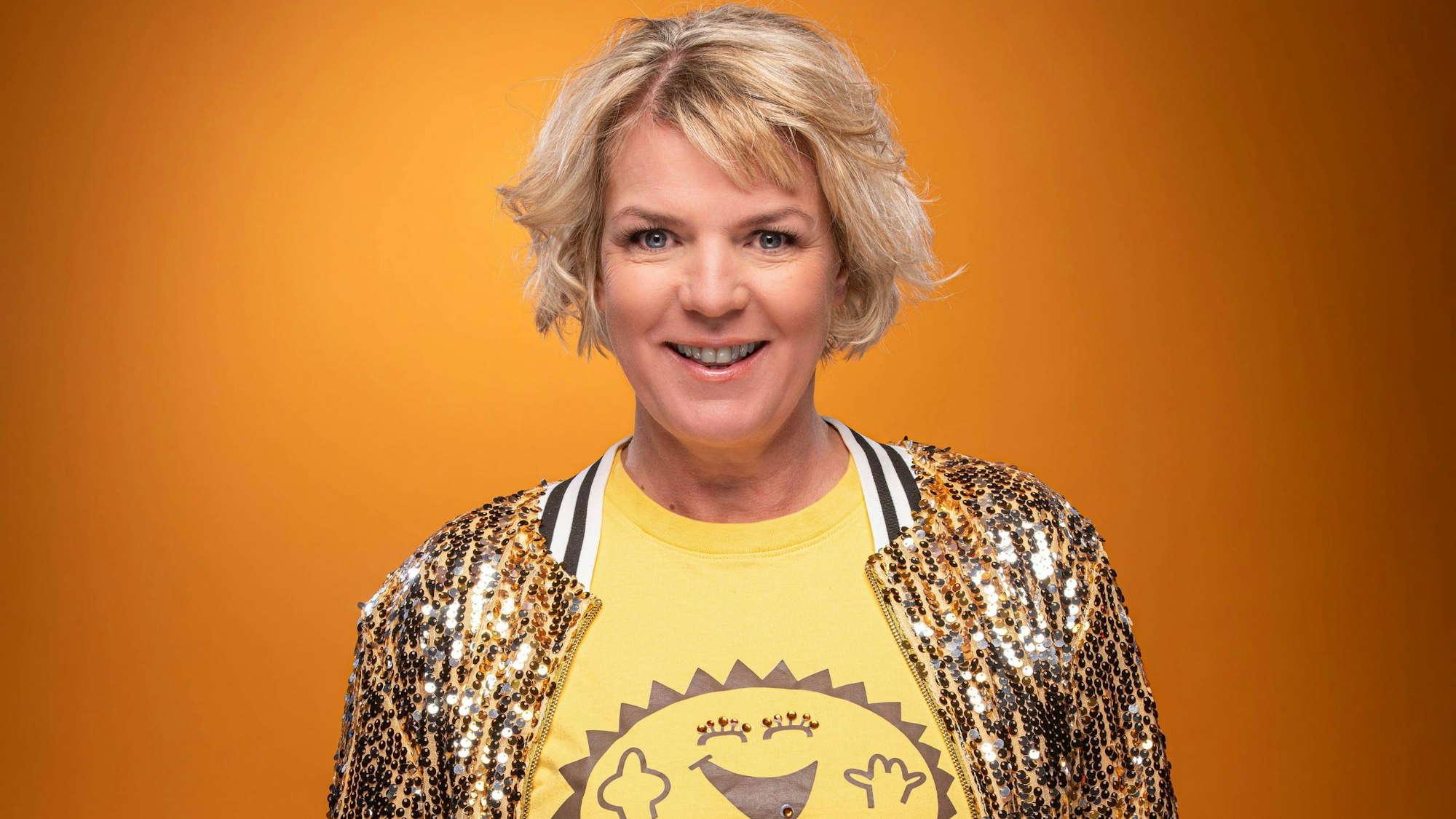 Comedian Mirja Boes in goldener Jacke.