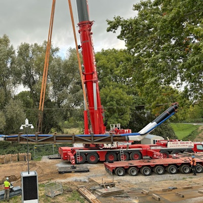 Ein Kran versenkt eine Rohrleitung in der Dhünn