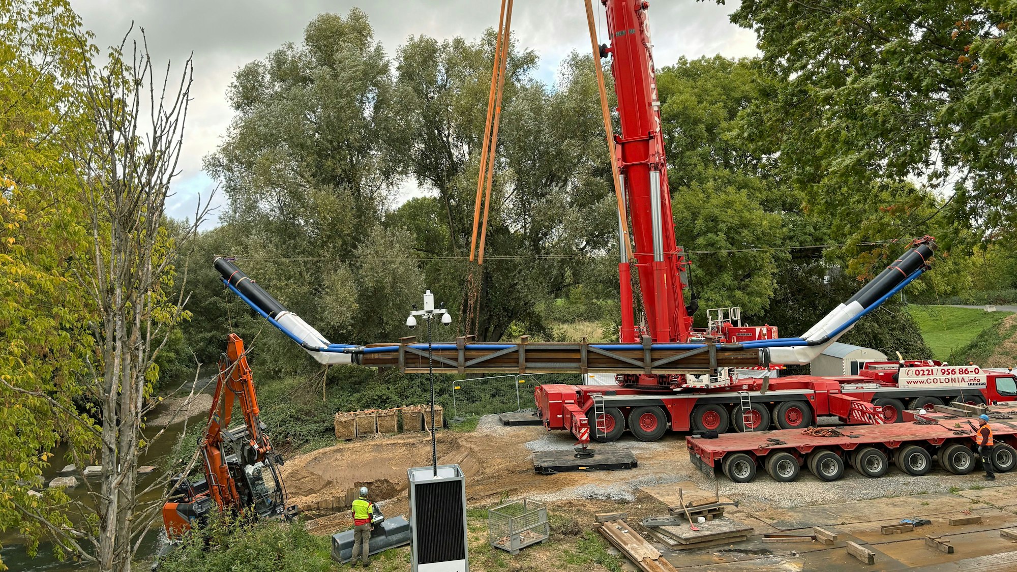 Ein Kran versenkt eine Rohrleitung in der Dhünn