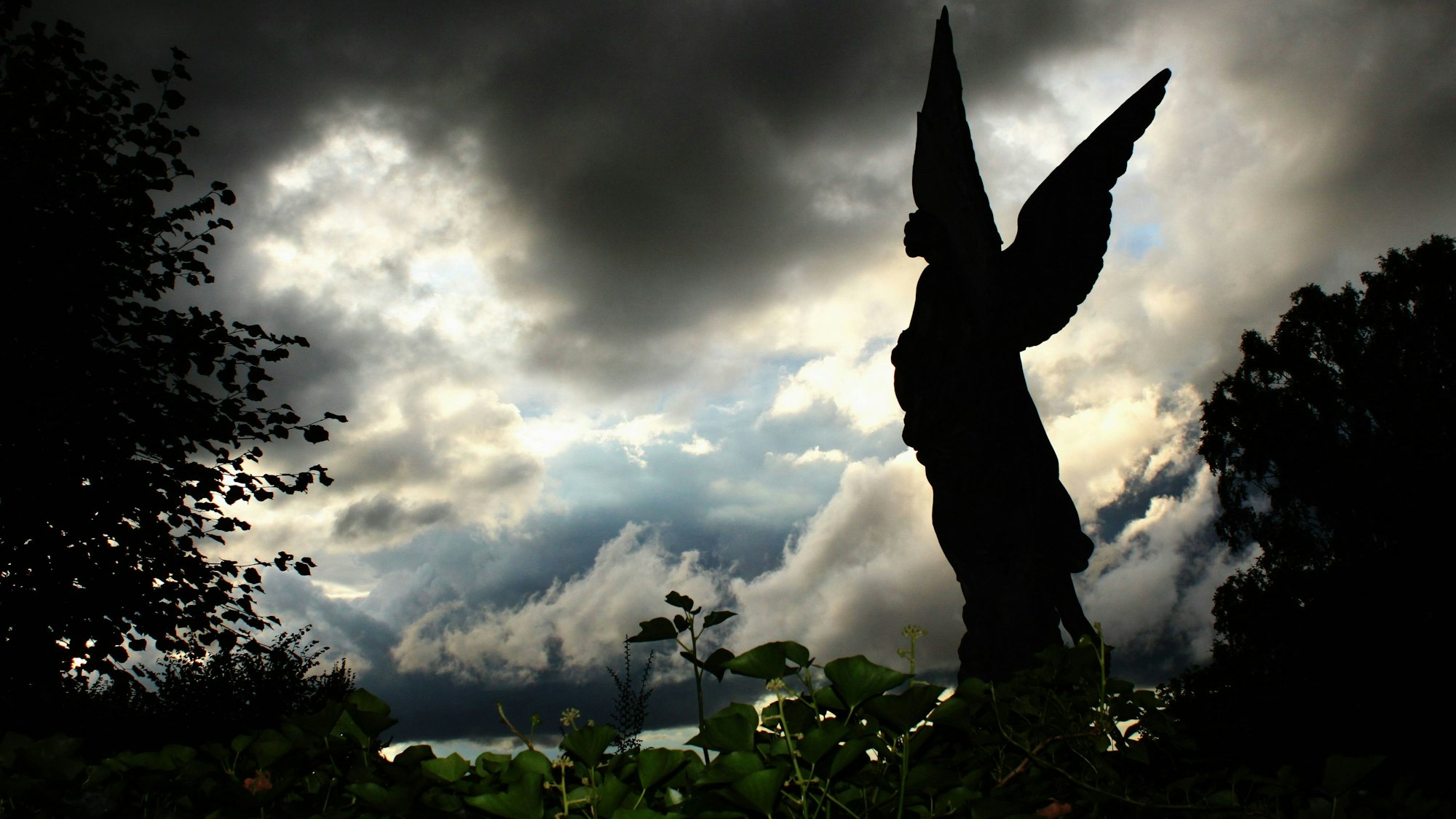 Engel vor dramatischer Wolkenkulisse