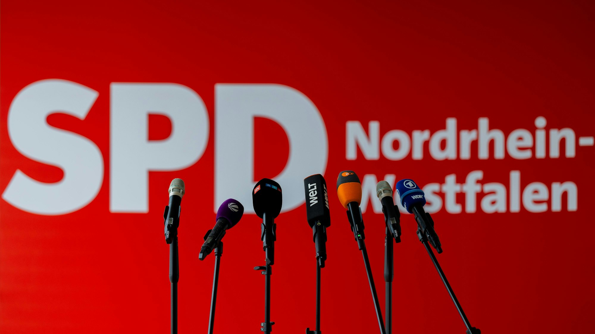 Mikrofone von Fernsehsendern stehen vor dem Logo der SPD im Johannes-Rau-Haus, der Parteizentrale der Landespartei in Düsseldorf.
