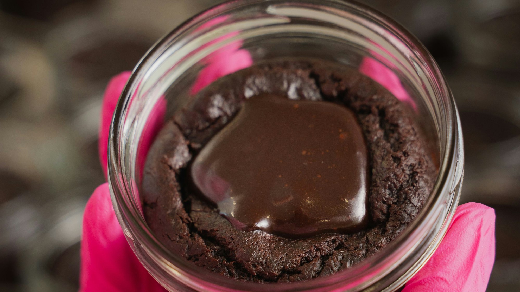 Ein Glas gefüllt mit einem Schokokuchen und brauner Glasur.