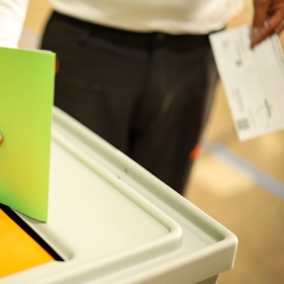 Ein Mann wirft seine Stimmzettel in eine Wahlurne.