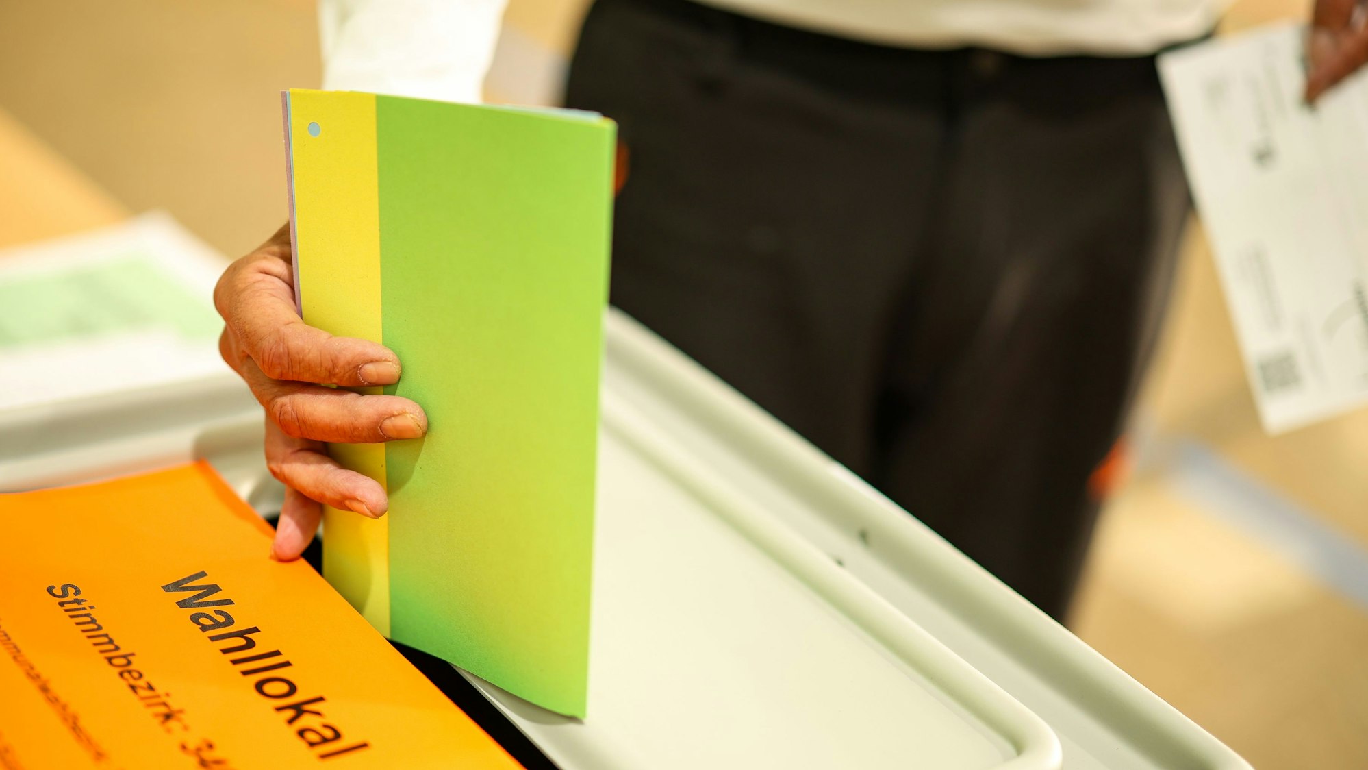 Ein Mann wirft seine Stimmzettel in eine Wahlurne.