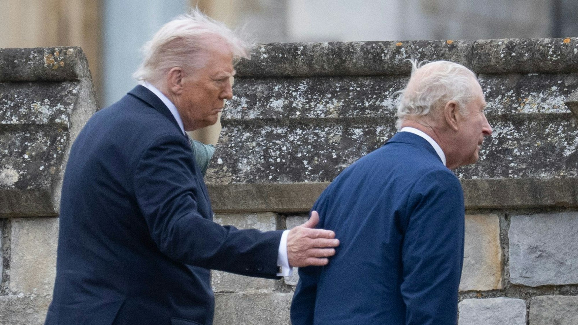 Donald Trump legt beim Verlassen der Militärzeremonie in Windsor seine Hand auf den Rücken von König Charles III.