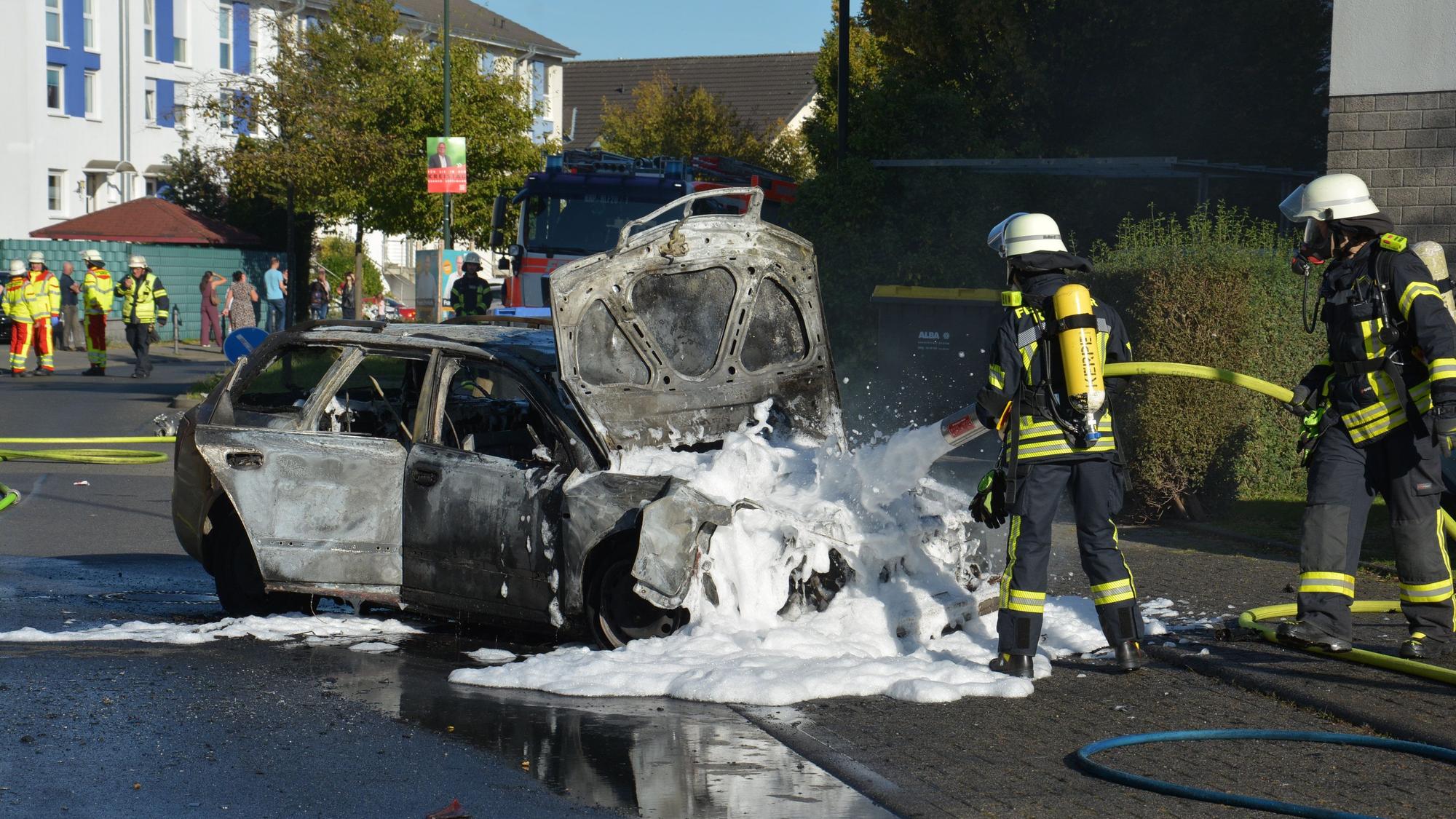 Die Feuerwehr löscht ein brennendes Fahrzeug nach einem Unfall in Kerpen-Sindorf.