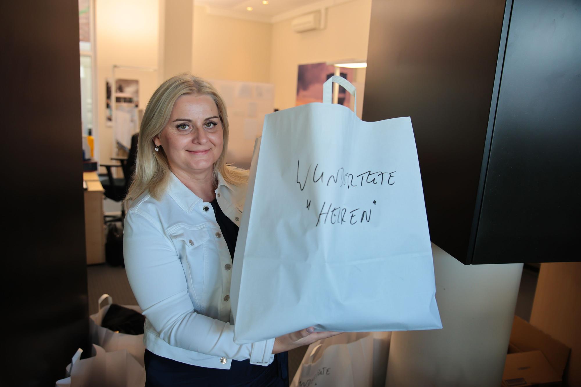 Auktionatorin Sylke Heckmann präsentiert eine Wundertüte, die eventuell voller Schätze ist.