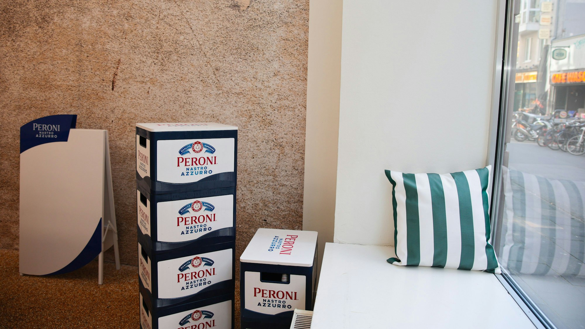 Sitzplatz am Fenster mit Peroni-Kisten daneben.