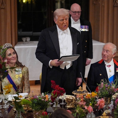 Donald Trump hält beim Staatsbankett im Windsor Castle eine Rede, neben ihm sitzen Prinzessin Kate im goldenen Kleid mit Tiara und König Charles, der ihn anblickt.