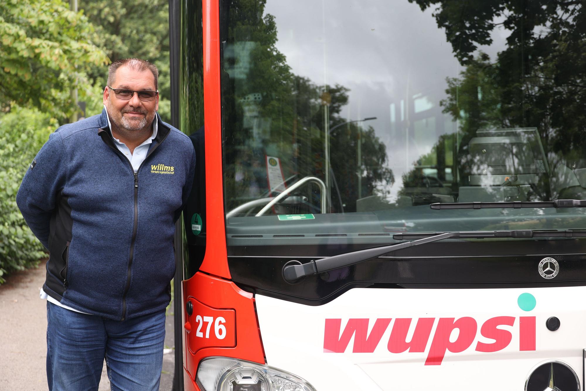 Busfahrer Stephan Melcher neben einem Wupsi-Bus