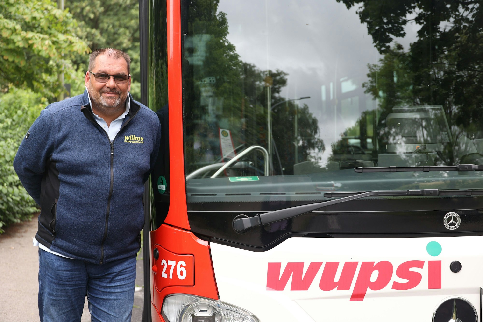 Busfahrer Stephan Melcher neben einem Wupsi-Bus