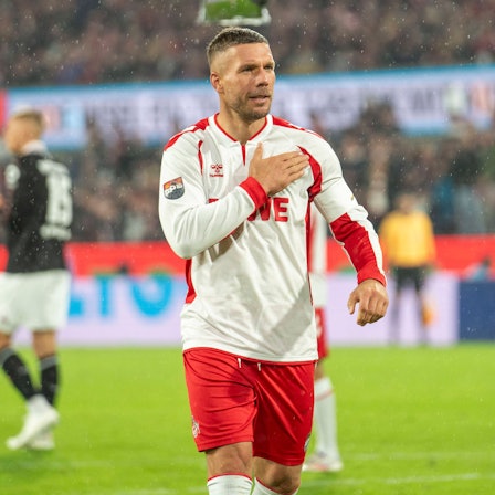 Lukas Podolski fasst sich während seines Abschiedsspiels im vergangenen Oktober im Kölner Stadion an die Brust.