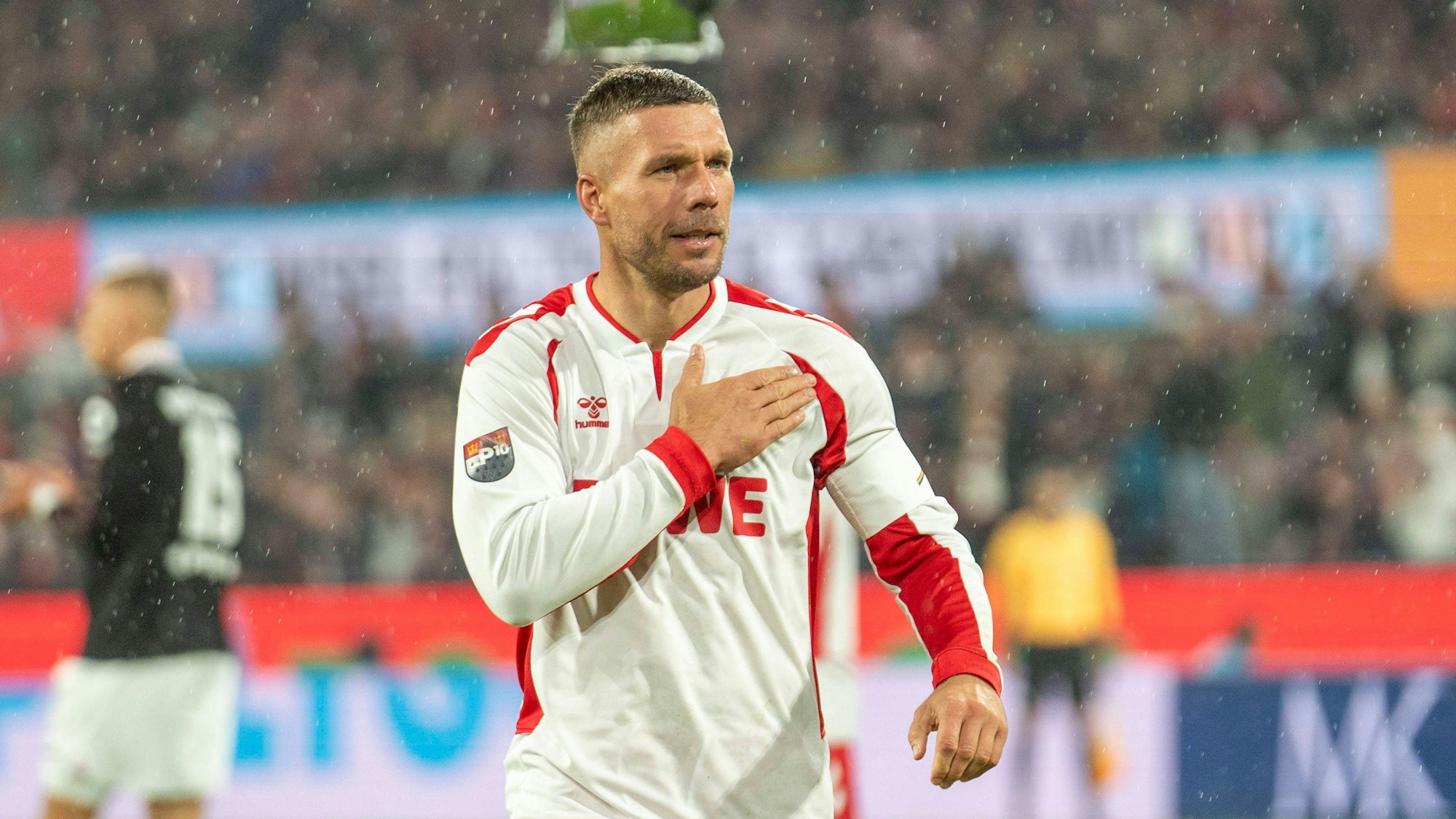 Lukas Podolski fasst sich während seines Abschiedsspiels im vergangenen Oktober im Kölner Stadion an die Brust.