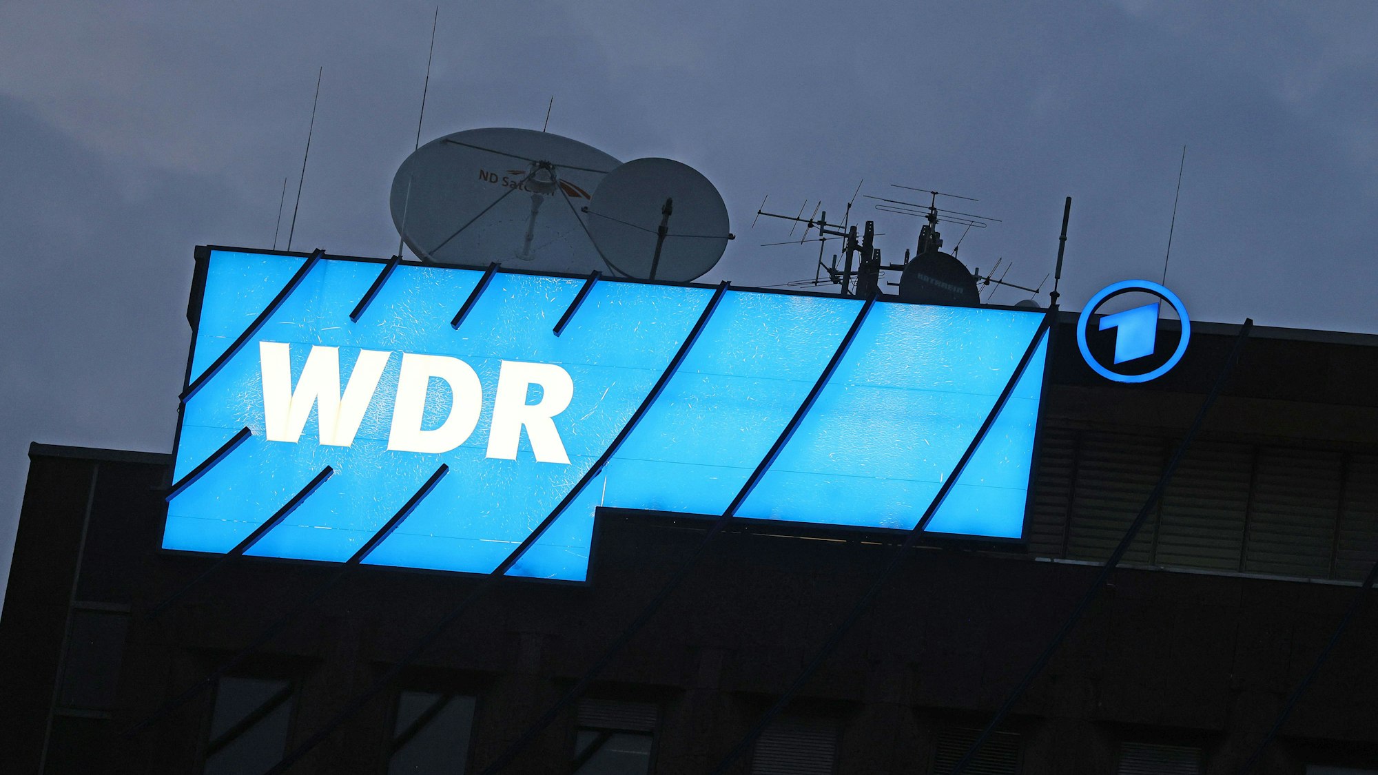 Ein Logo des WDR (Westdeutscher Rundfunk) leuchtet auf dem Dach des Senders.