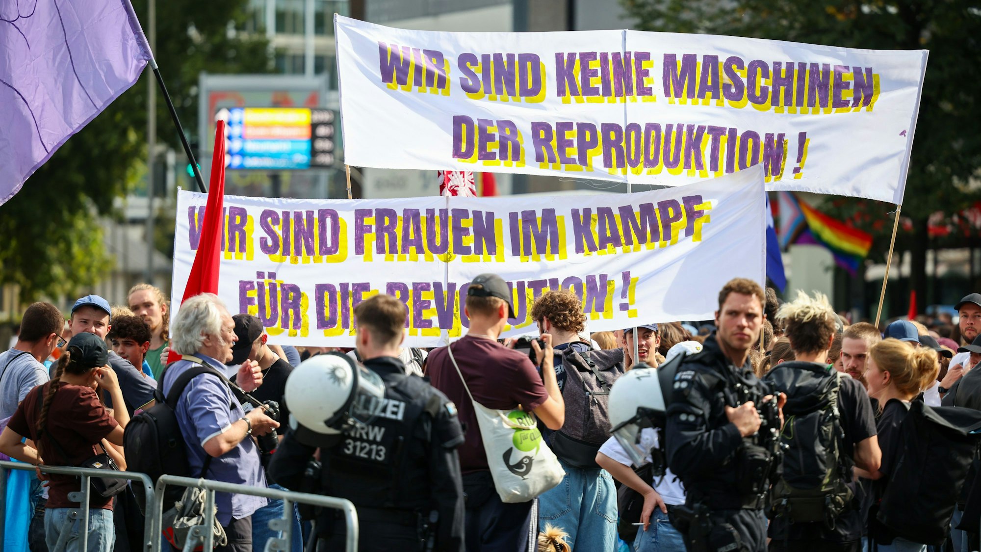 Auf der Gegendemo zum „Marsch für das Leben“ in Köln zeigen Teilnehmer Transparente mit der Aufschrift „Wir sind keine Maschinen der Reproduktion“ und „Wir sind Frauen im Kampf für die Revolution“.