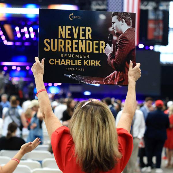 Ein Teilnehmer hält vor der Gedenkfeier für den politischen Aktivisten Charlie Kirk am 21. September 2025 im State Farm Stadium ein Schild mit der Aufschrift „Never Surrender“ (Niemals aufgeben) hoch.
