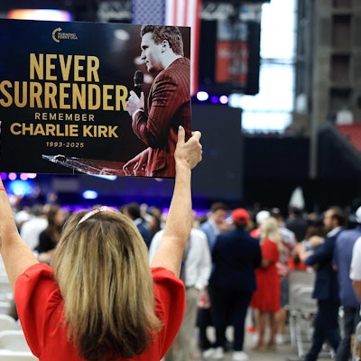 Ein Teilnehmer hält vor der Gedenkfeier für den politischen Aktivisten Charlie Kirk am 21. September 2025 im State Farm Stadium ein Schild mit der Aufschrift „Never Surrender“ (Niemals aufgeben) hoch.