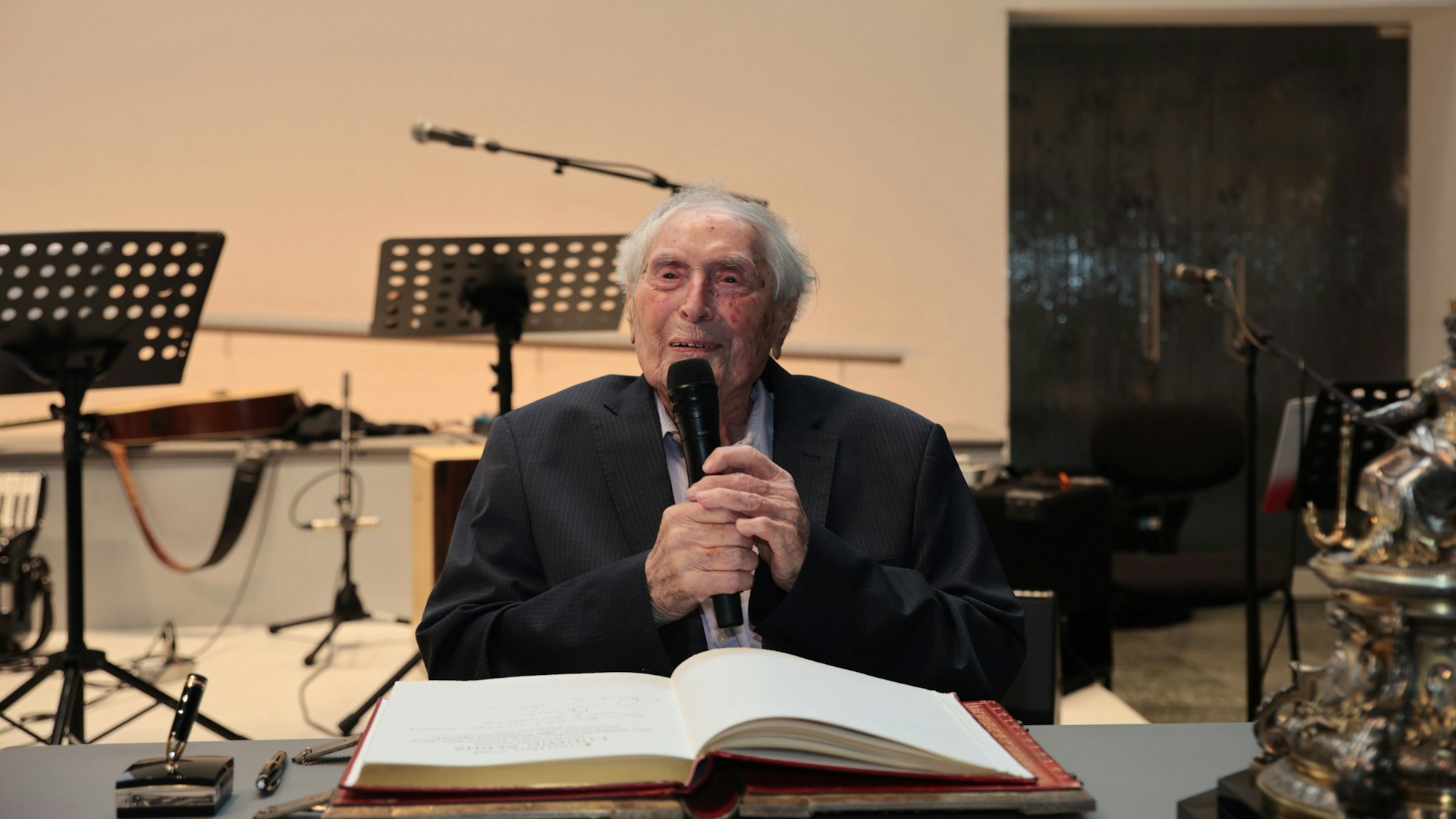 Der 100-jährige Ludwig Sebus wird geehrt und trägt sich in das Goldene Buch der Stadt Köln ein.