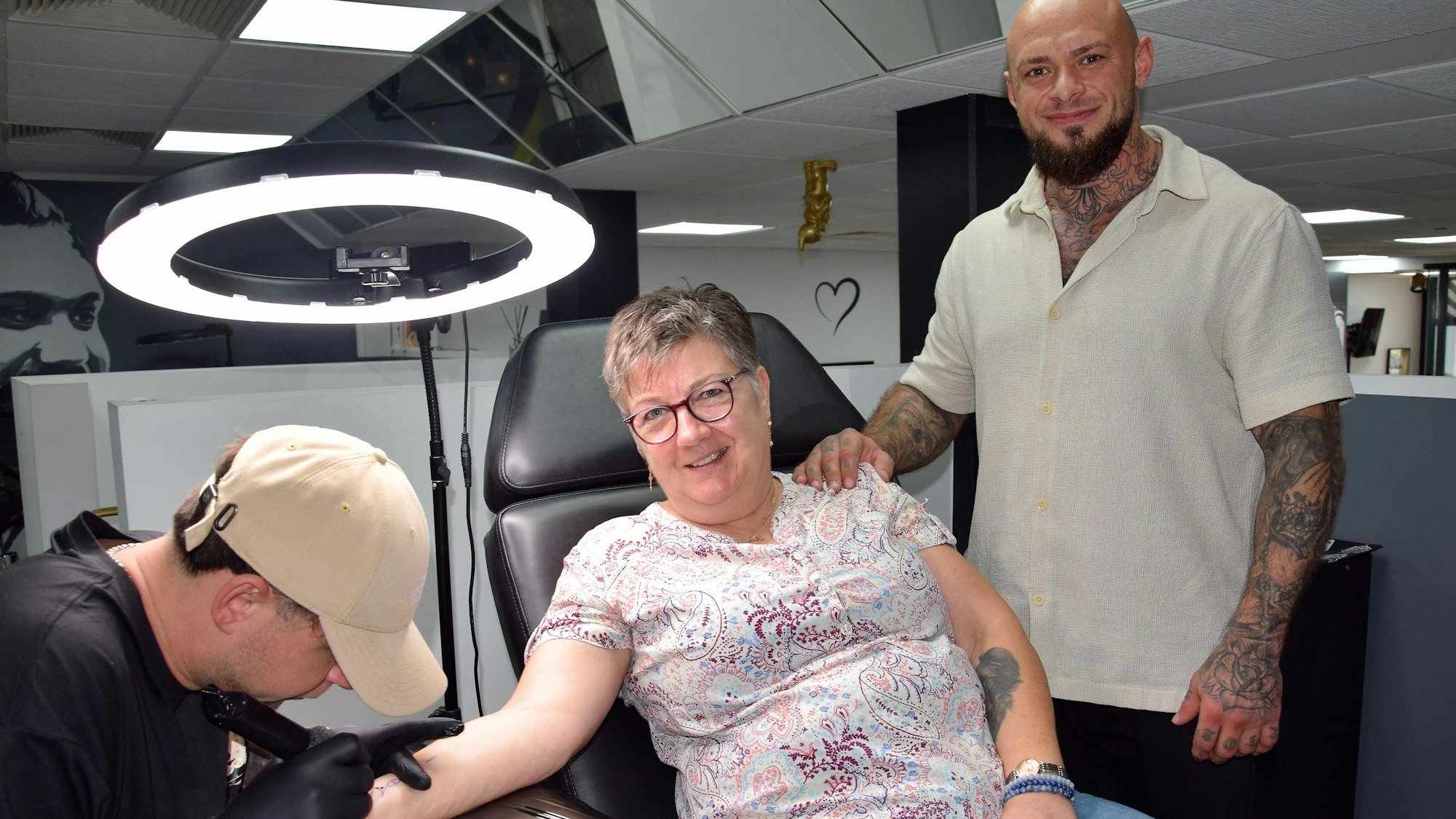 Das Foto zeigt eine Frau beim Tätowierer.