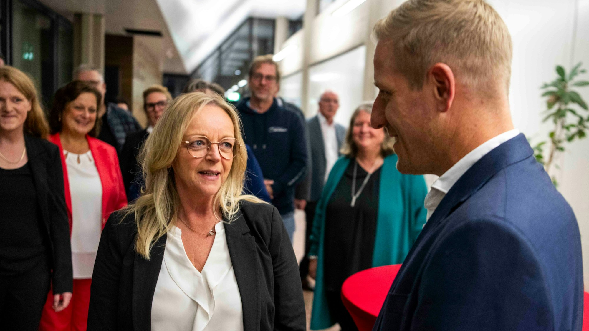 Sabine Preiser-Marian spricht mit Markus Ramers, im Hintergrund stehen mehrere Personen.