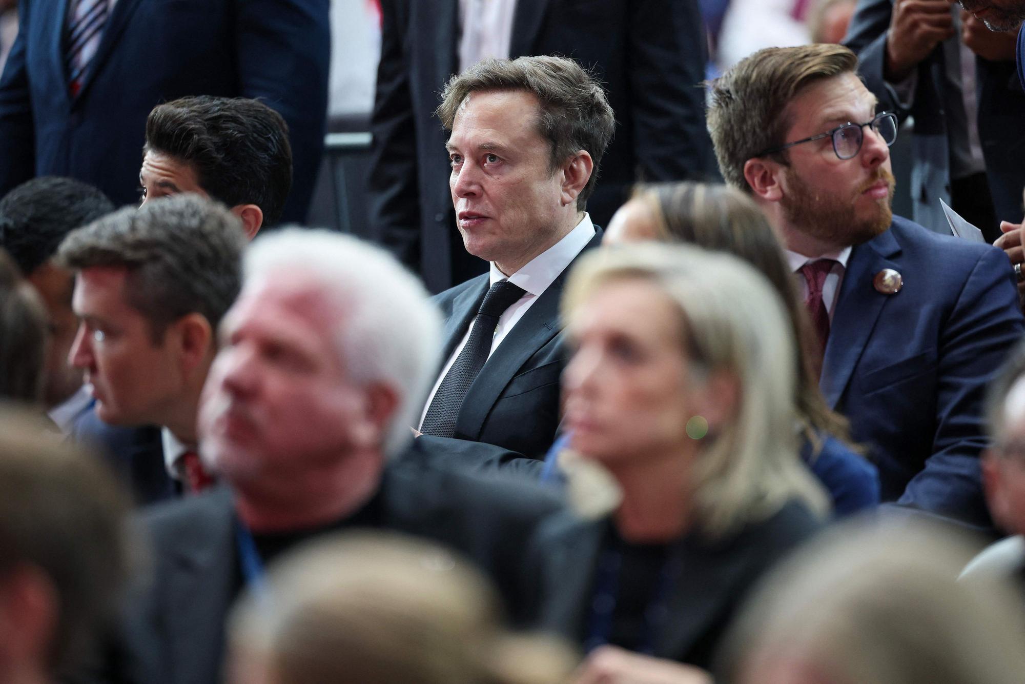 Elon Musk zwischen anderen Trauergästen.
