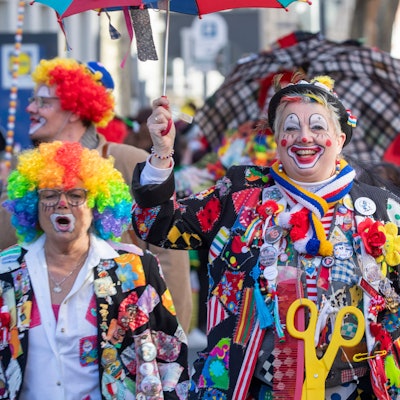 Als Clown verkleidete Jecke feiern.