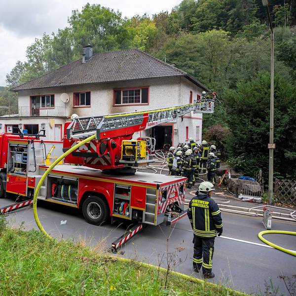 Das Foto zeigt Einsatzkräfte der Feuerwehr vor einem Haus.