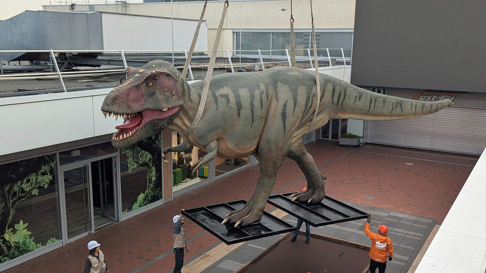 Das Foto zeigt den Tyrannosaurus am Kran über der Aktionsfläche des Einkaufszentrums.