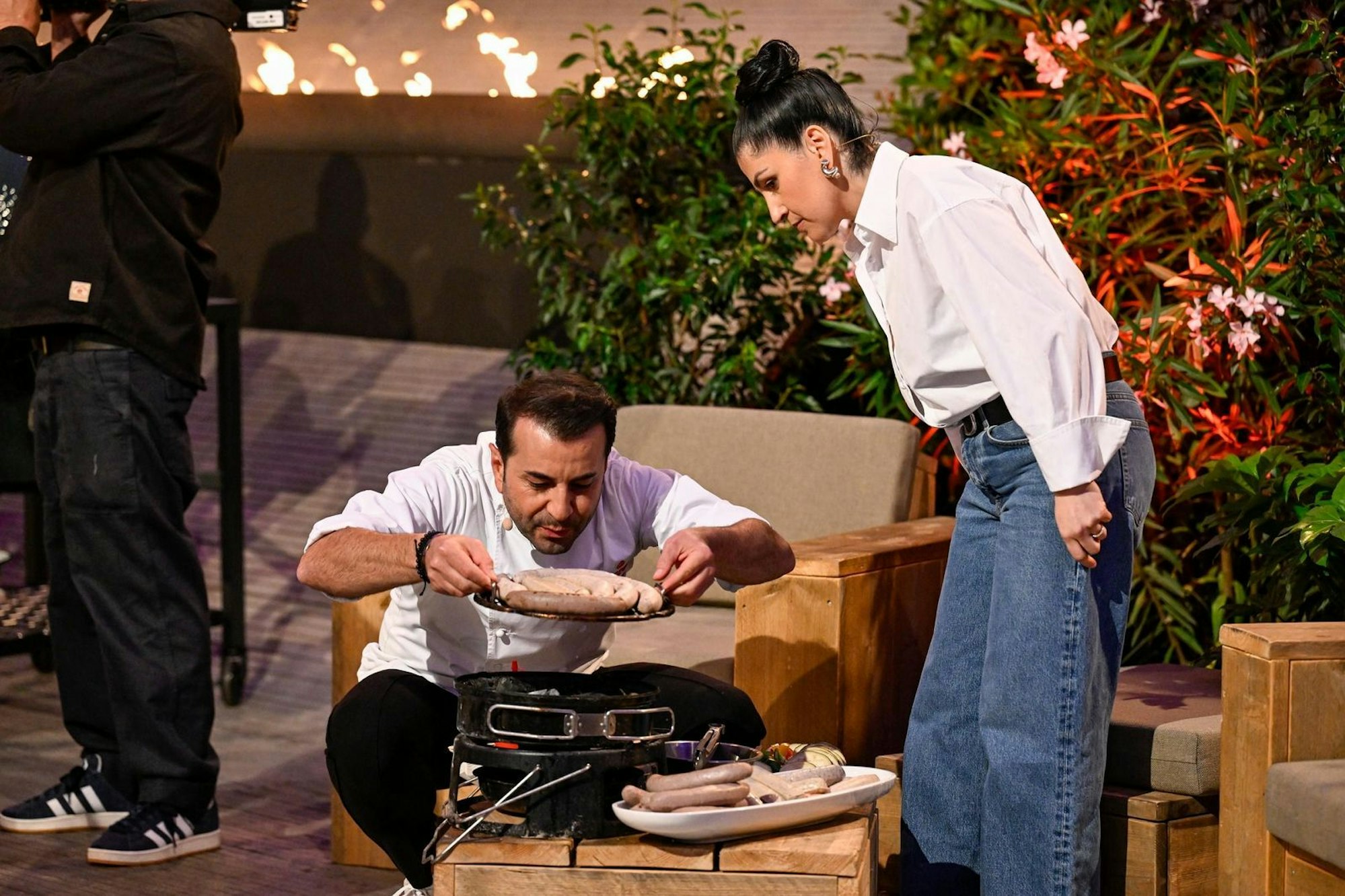 Perfekter Service: Elif Oskan und Ali Güngörmüş brutzelten Würstchen fürs Publikum. Aber mit Anlaufproblemen: Erst warf Güngörmüş den Grill um und die Grillkohle auf die Bühne. (Bild: RTL/Markus Hertrich)