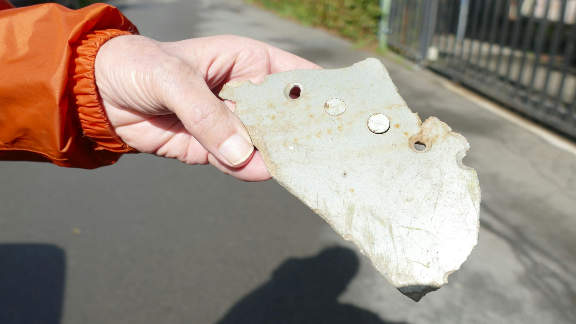 Wolfgang Eilmes zeigt ein Trümmerteil des abgestürzten Flugzeugs.