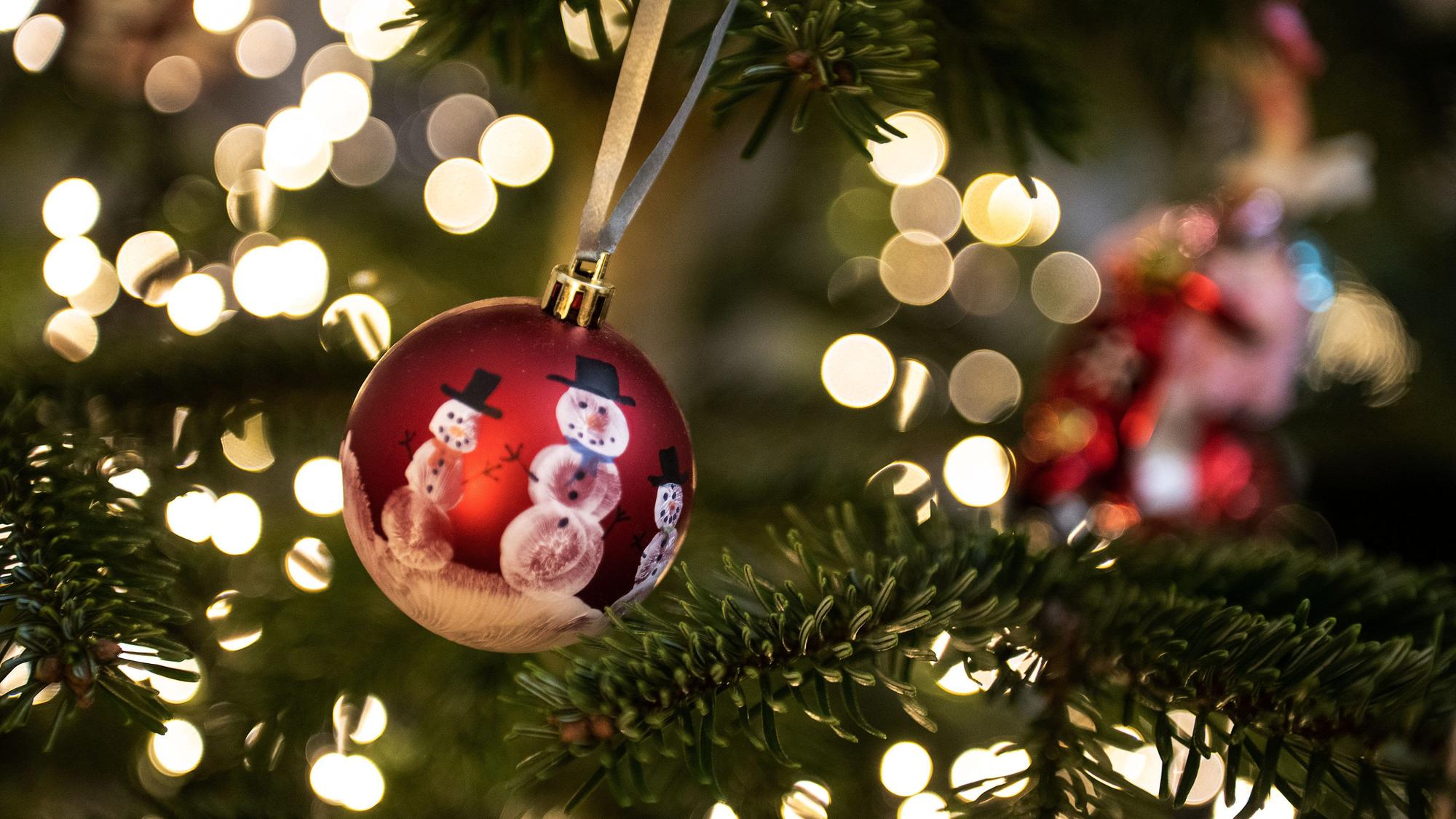 ARCHIV - 24.12.2022, Niedersachsen, Göttingen: Eine Weihnachtskugel hängt an einem Weihnachtsbaum mit einer Lichterkette. Weihnachten, das Fest der Familie und der Liebe - doch mancher bleibt an Heiligabend einsam und gerät aus anderen Gründen in eine Krise. (zu dpa: «Hilfsangebote während der Feiertage») Foto: Swen Pförtner/dpa +++ dpa-Bildfunk +++
