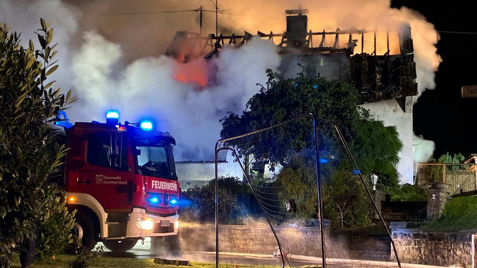 Ein Haus steht in Flammen, dichter Qualm steigt auf.