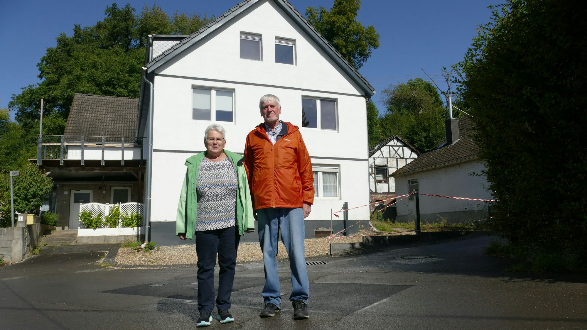 Wolfgang Eilmes und Helga Heuser stehen vor dem Fichtenweg 1 in Ahe, wo das Flugzeug vor 70 Jahren einschlug. Im Hintergrund ist das Fachwerkhaus zu erkennen, das damals schon stand.