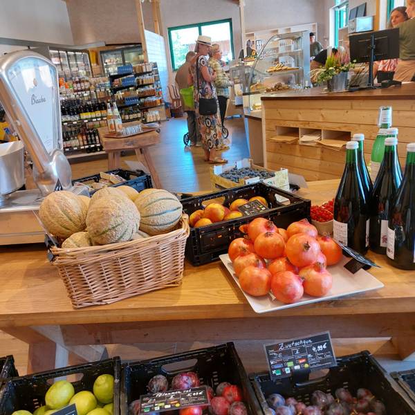 Obst, Gemüse und Getränke auf großen Holztischen.