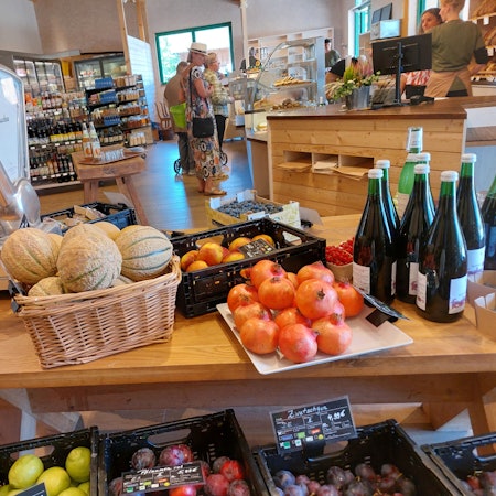 Obst, Gemüse und Getränke auf großen Holztischen.