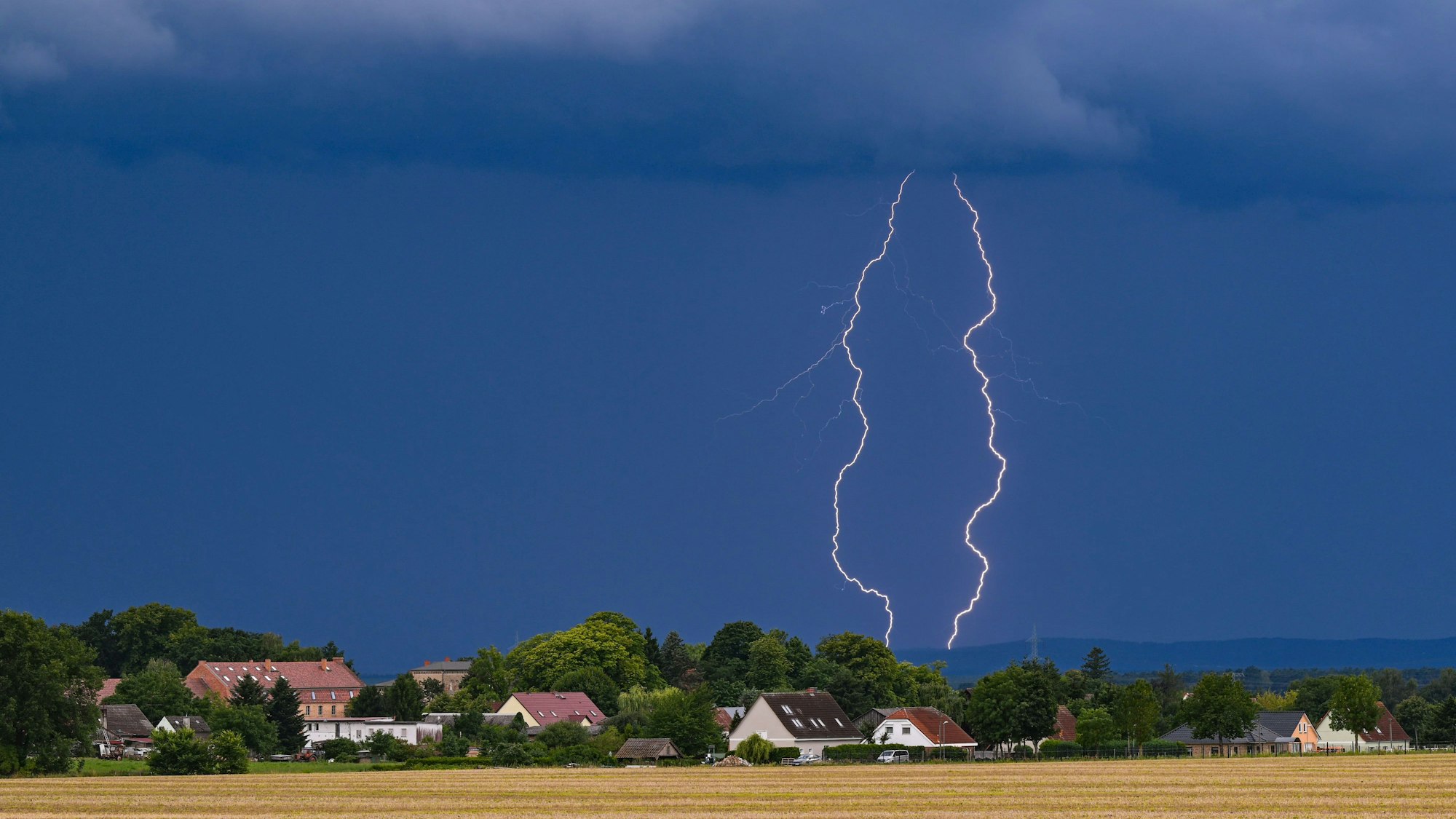 Blitze eines Gewitters leuchten über der Landschaft im östlichen Brandenburg.