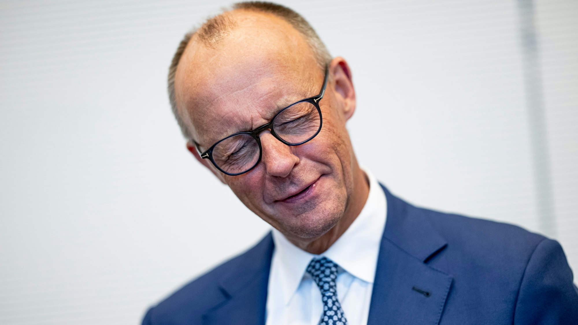 Bundeskanzler Friedrich Merz (CDU) kneift die Augen zu.