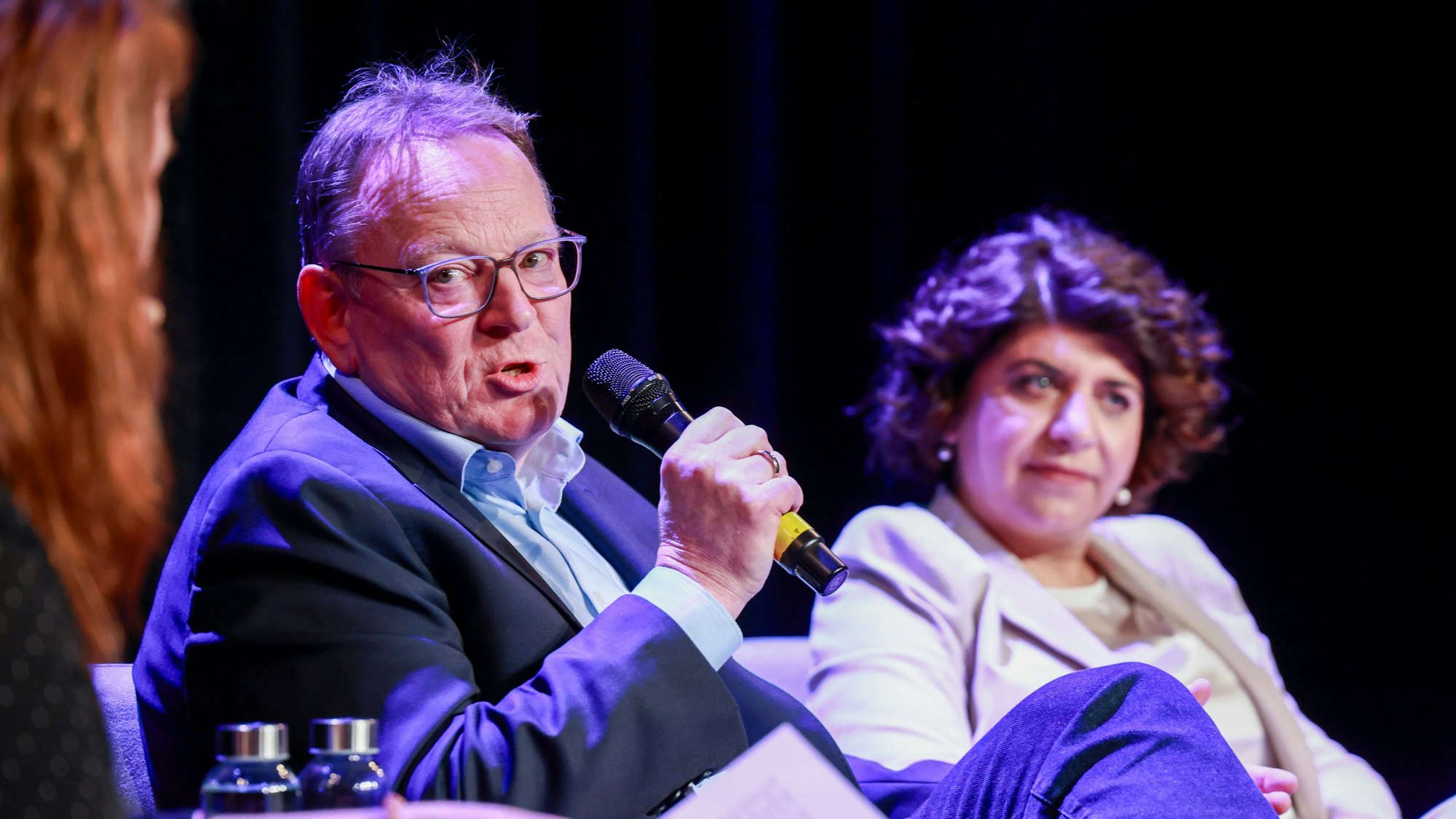 Torsten Burmester und Berivan Aymaz sitzen nebeneinander bei einer Podiumsdiskussion.