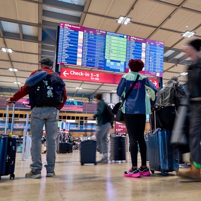 Fluggäste informieren sich nach einem Cyberangriff an den Abflugtafeln im Terminal 1 des Flughafens Berlin-Brandenburg.