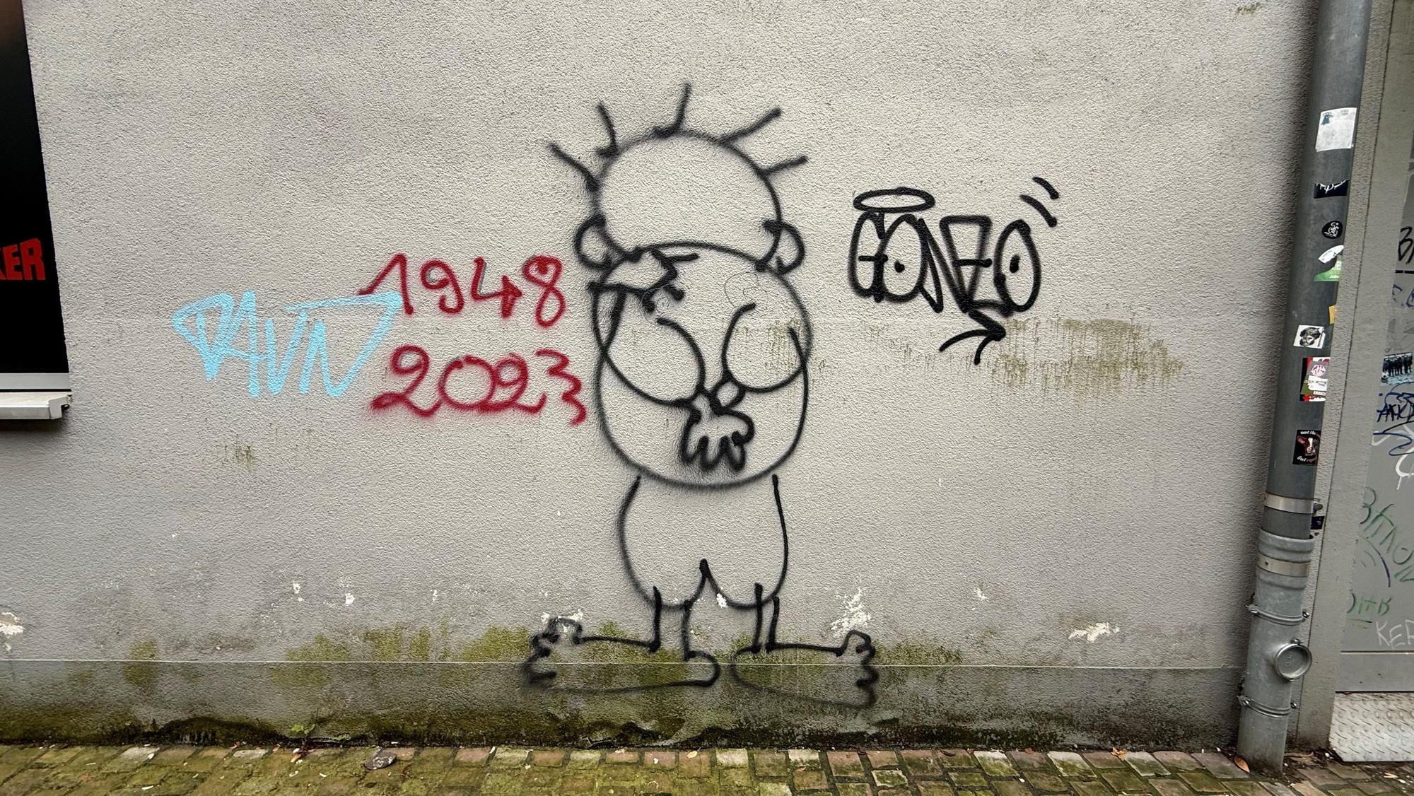 Eine Wand mit wenigen Graffiti.