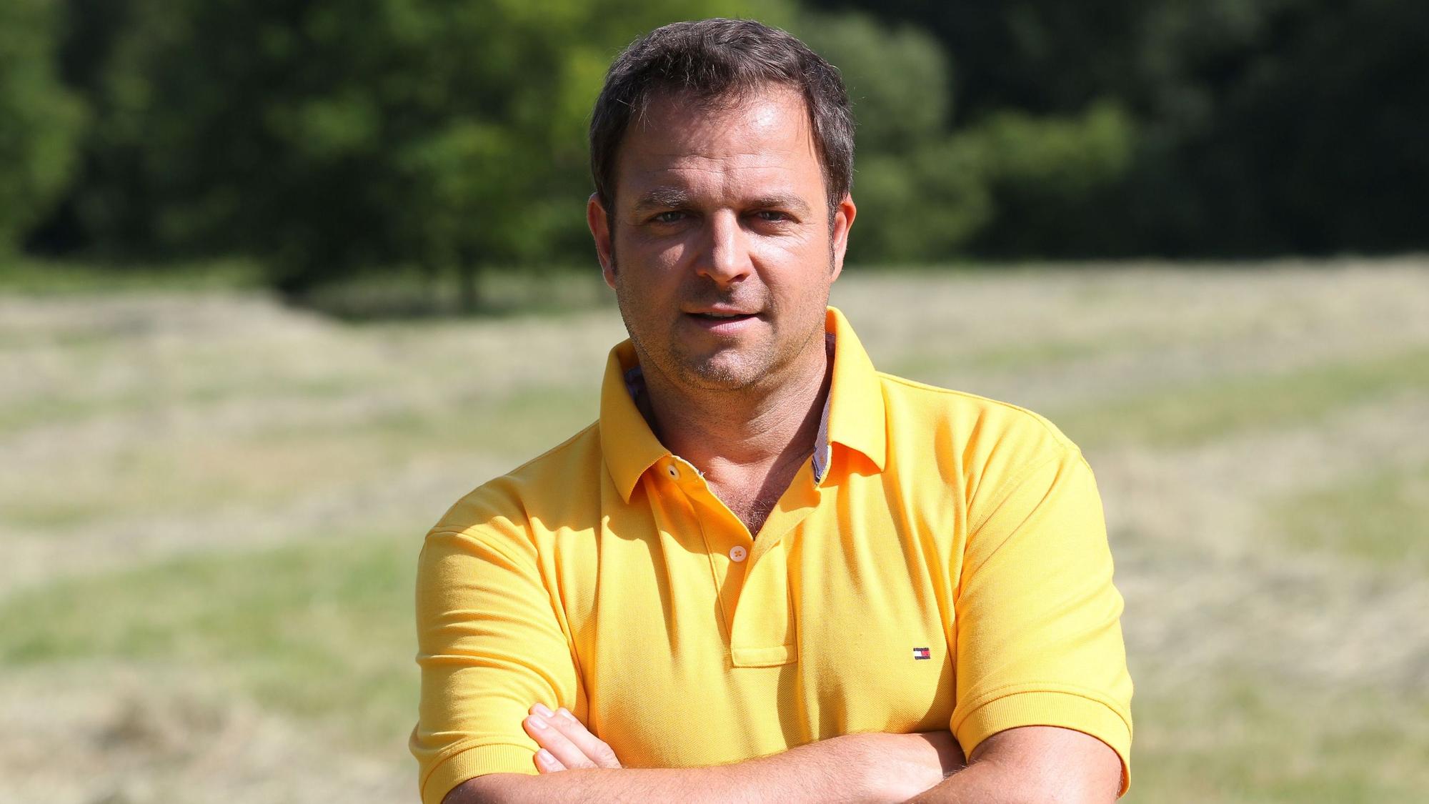 Martin Rütter in einem gelben Poloshirt.