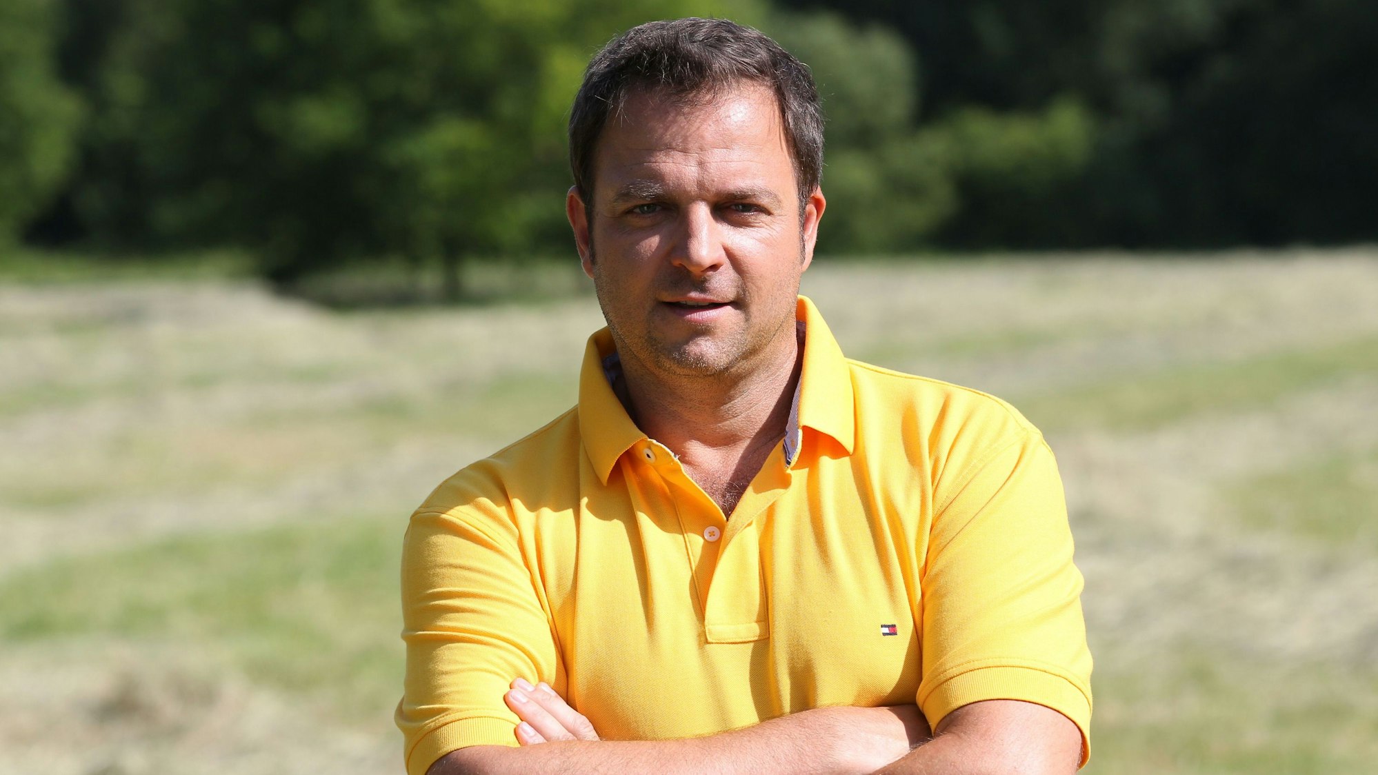 Martin Rütter in einem gelben Poloshirt.