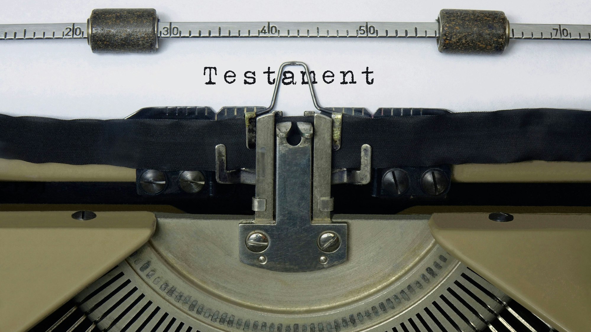 Auf dem Papier in einer Schreibmaschine steht der Schriftzug Testament.