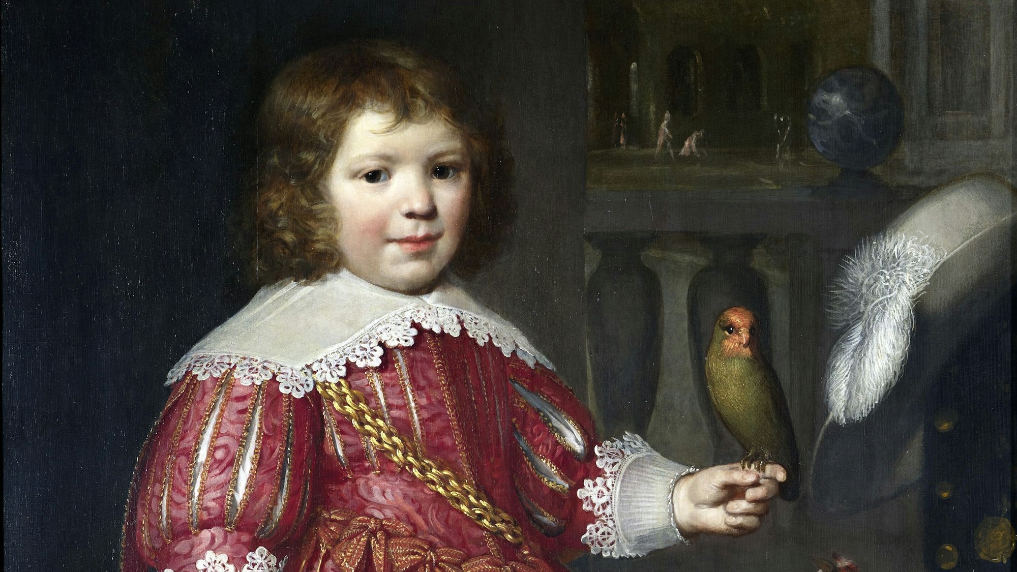 Ein Junge hält einen Sittich auf der Hand.