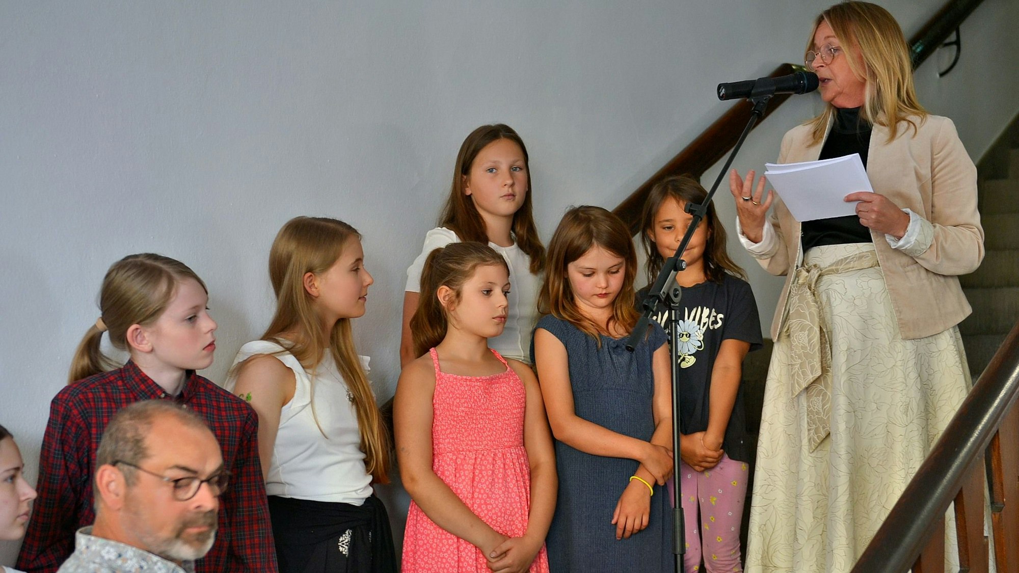 Die Karate-Kids des TVE stehen nebeneinander vor einer Treppe, auf der die Bürgermeisterin eine Laudatio hält.