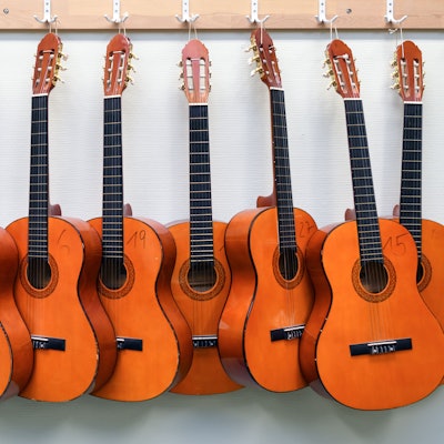 Symbolbild: Nummerierte Gitarren hängen an einer Wand.